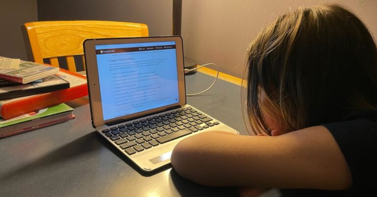 Young hunter sitting with iPad at a desk and taking the Online Hunter Safety Course for Michigan