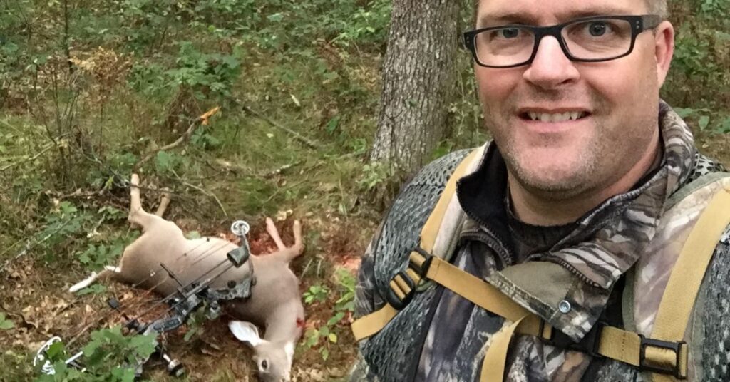 bow hunter with harvested deer