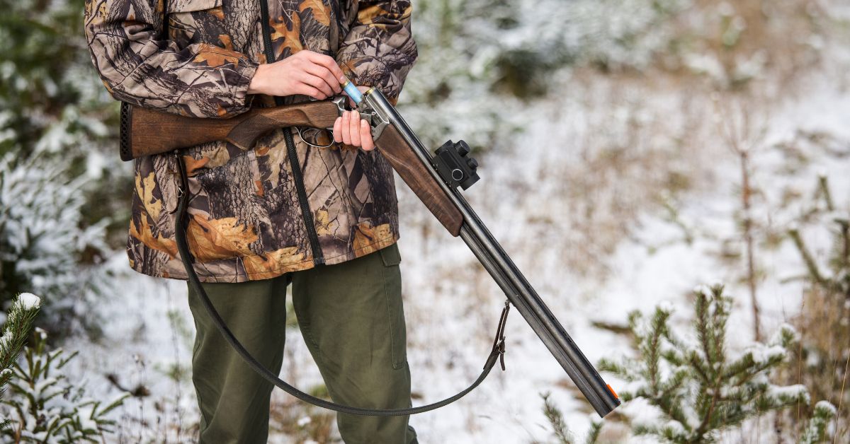 A clean, oiled rifle gun being loaded in the field by a young man. Firearm Maintenance is critical to hunting success