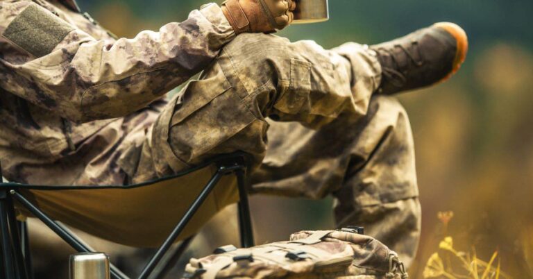 Man wearing camouflage sitting in hunting chair holding a mug