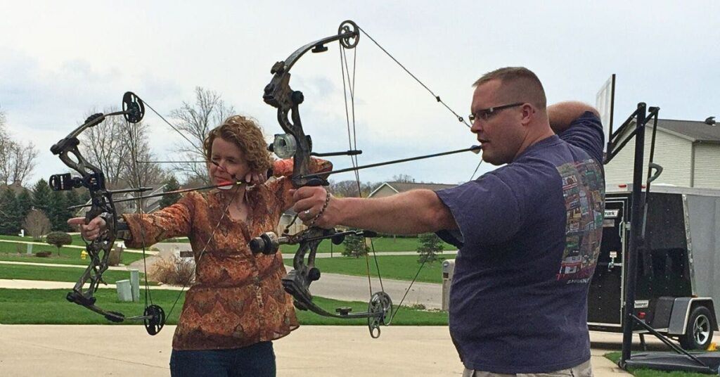 two archers practice with compound bows