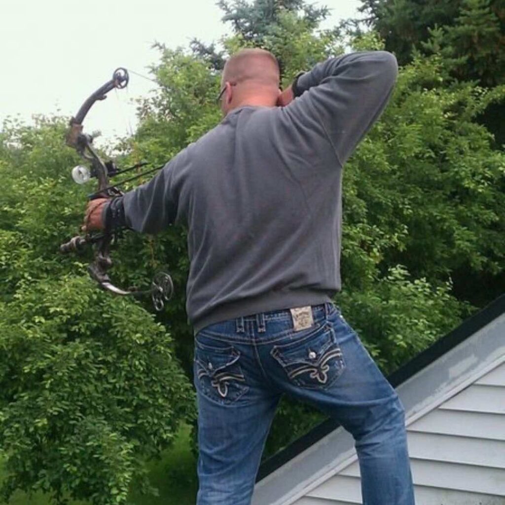 Hunter on rooftop practicing archery