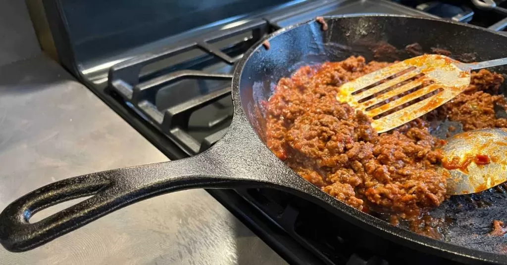 Venison sloppy joe cooking in cast iron skillet