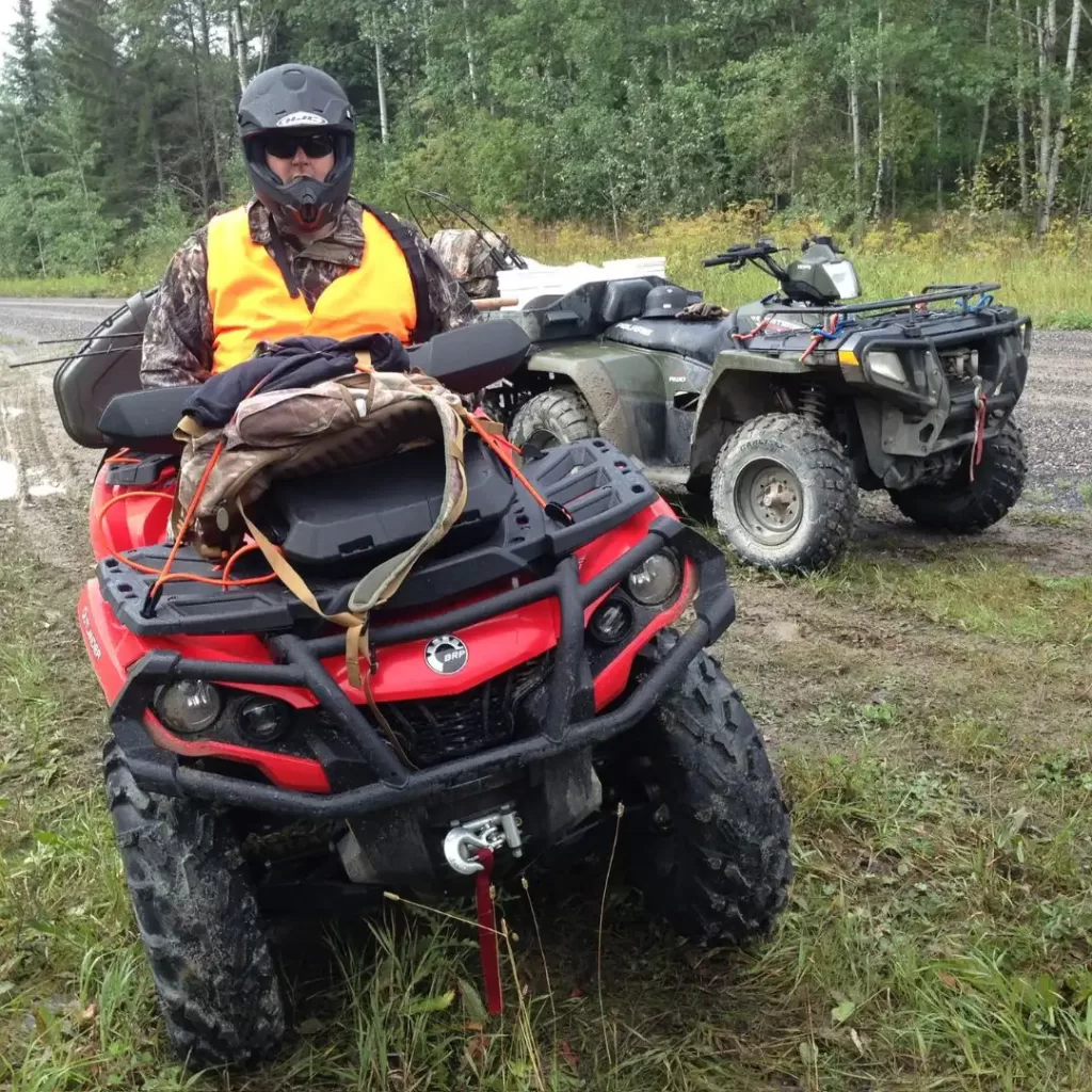 Hunter dressed in orange sitting on ATV