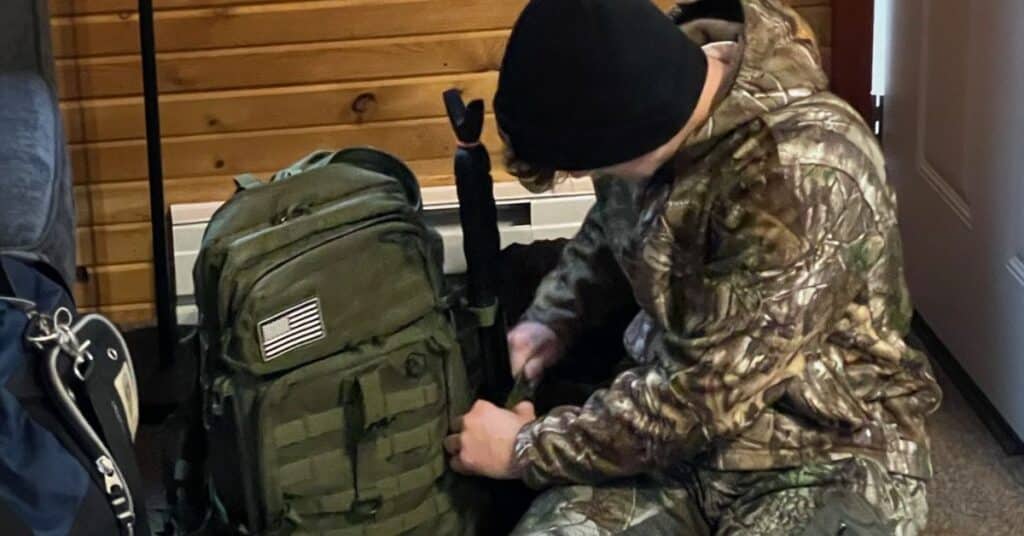 Hunter in camouflage packing his backpack