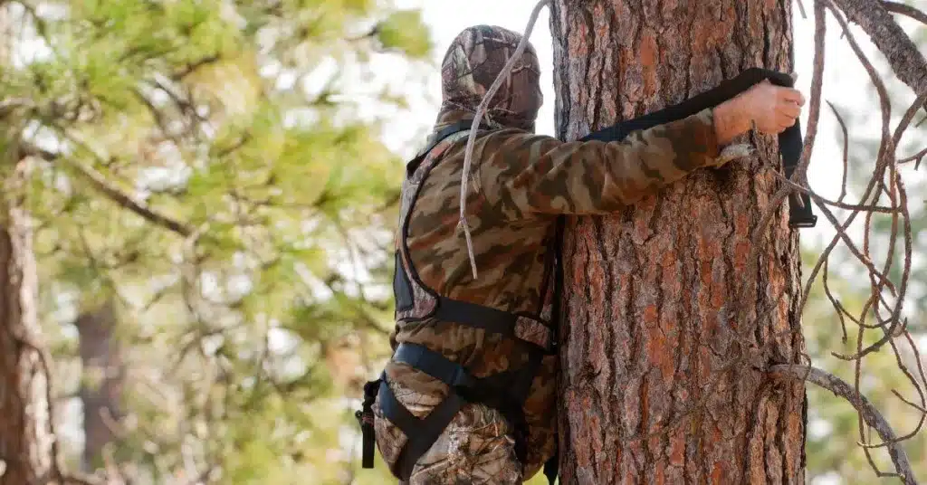 Bow hunter attaching tie-off ropes for safety harness.