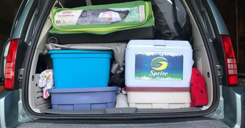 Coolers and tubs of camping gear packed for a cabin getaway