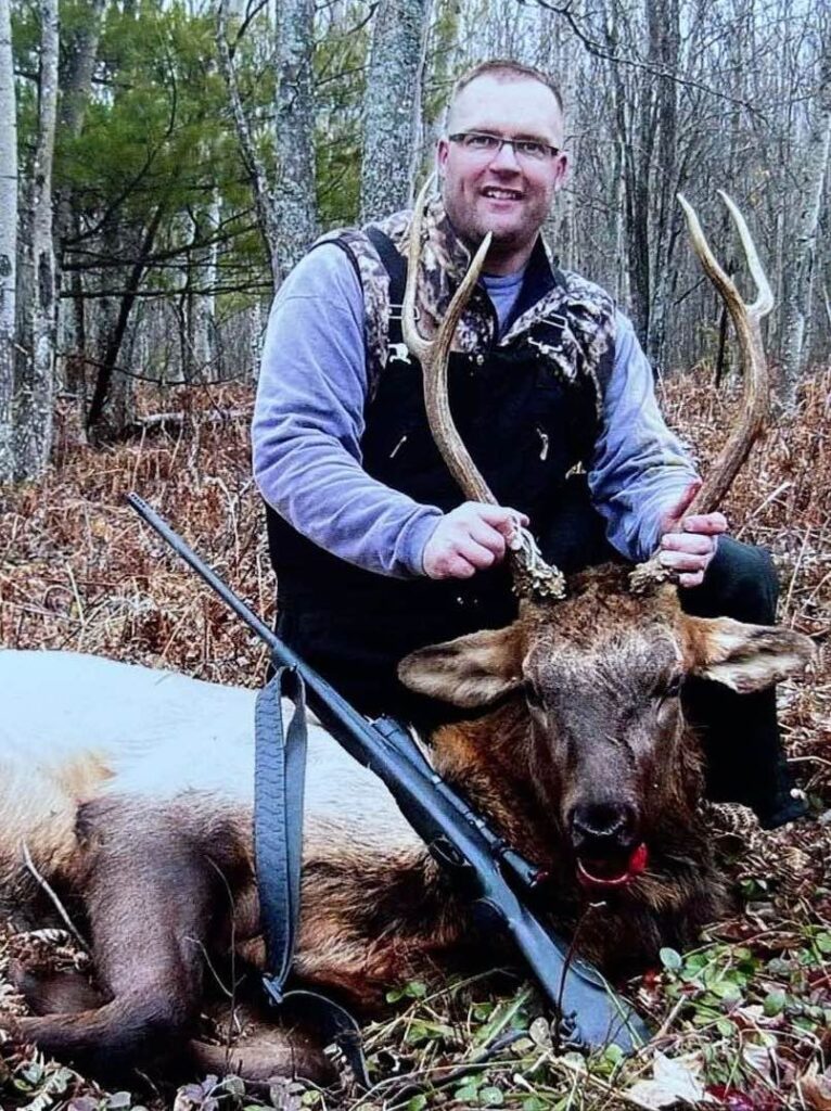 Hunter posing by Elk Kill and Rifle