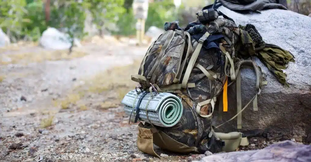 Backpack for hunting laying against a rock in the woods
